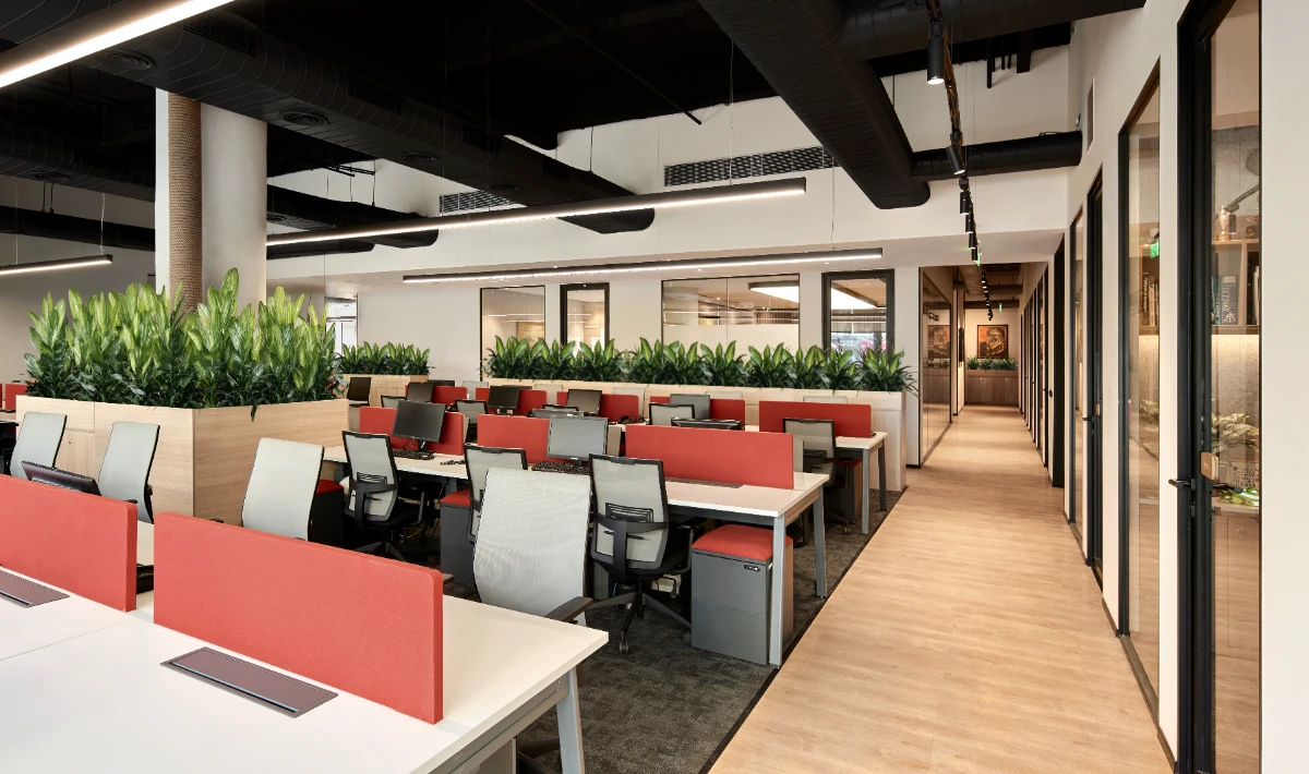 Hybrid office workspace with open desks and private booths