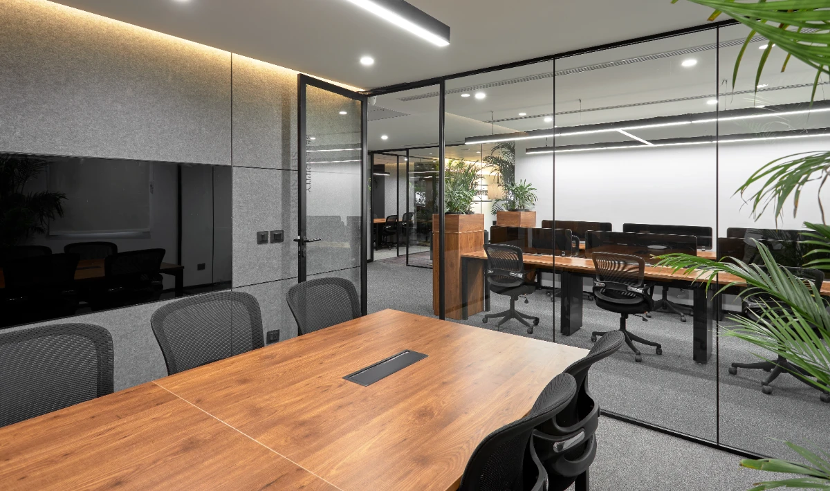 Glass partitions creating privacy in a small office meeting space.