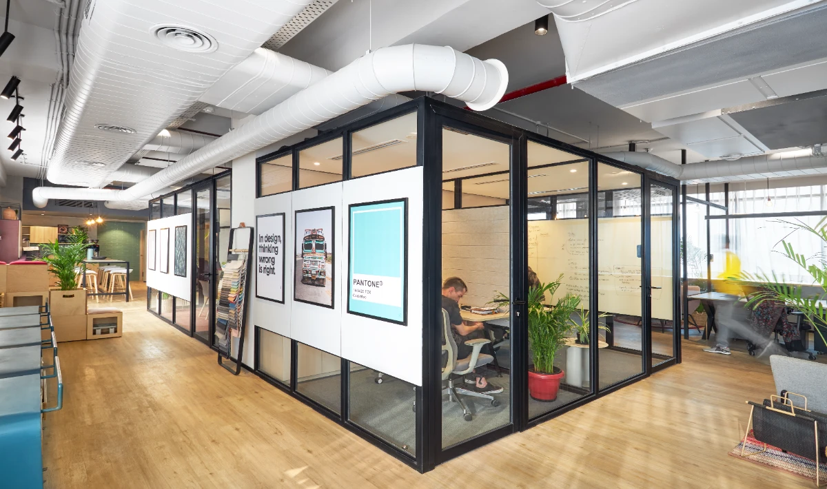 Wooden office interior design featuring glass cabins with wooden frames